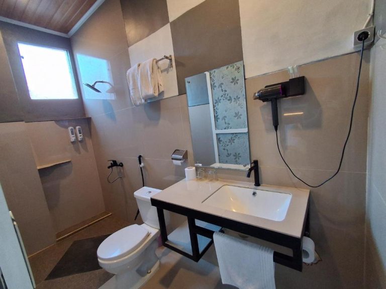Baño moderno completo con lavabo, inodoro y secador de pelo en L'Javas Villas