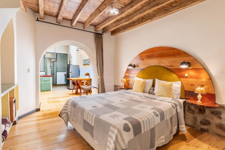 Habitación doble con cabecero de madera y vigas en techo del Heritage Hotel Old Town Quito Suites