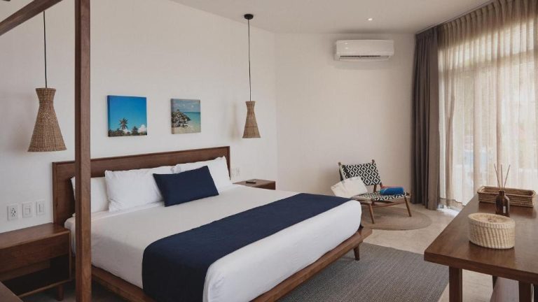 Habitación luminosa con cama king size y dosel de madera en Casa Altamar con aire acondicionado