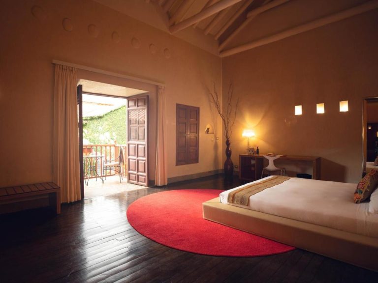 Habitación suite con cama doble, alfombra roja y balcón exterior en Casa Cartagena Boutique Hotel & Spa