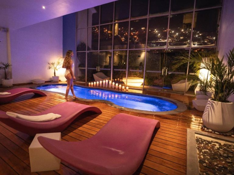 Piscina interior con velas y vista nocturna de la ciudad en Casa Cartagena Boutique Hotel & Spa