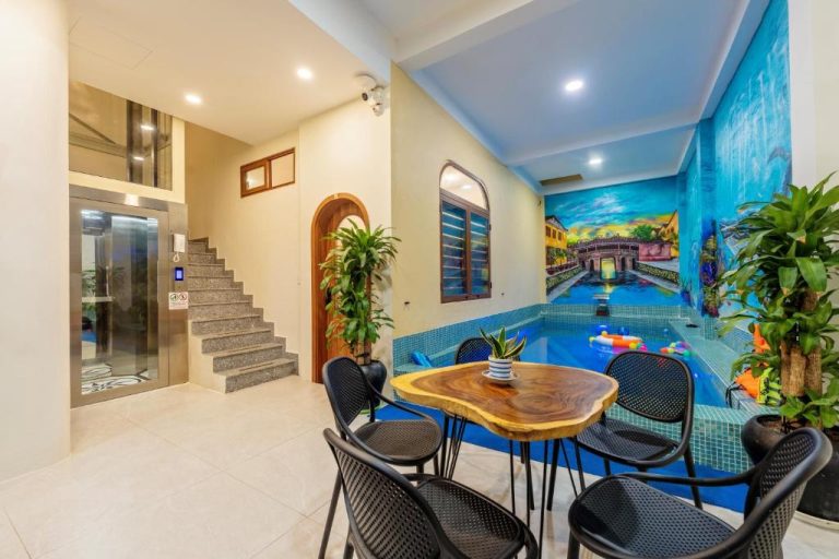 Piscina interior con mural de Hoi An y zona de descanso en The View Boutique Hoi An