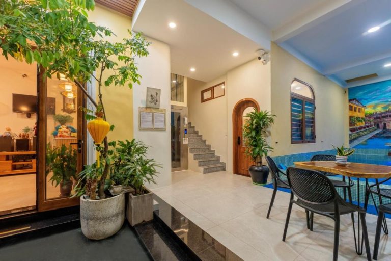 Lobby con piscina interior, plantas tropicales y mural decorativo del The View Boutique Hoi An