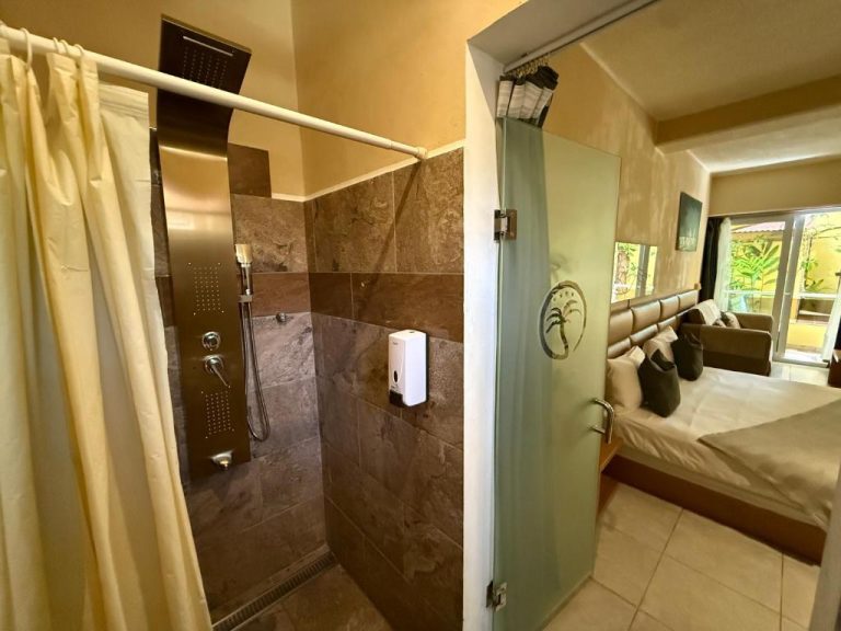 Baño con ducha de lluvia y acceso directo a la habitación doble en Sosua Inn Hotel