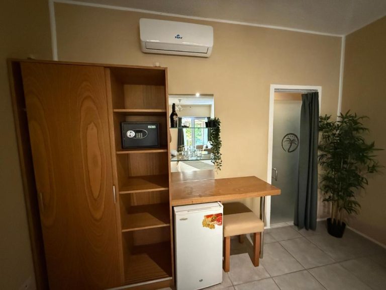 Habitación del Sosua Inn Hotel con armario de madera, escritorio, minibar y aire acondicionado