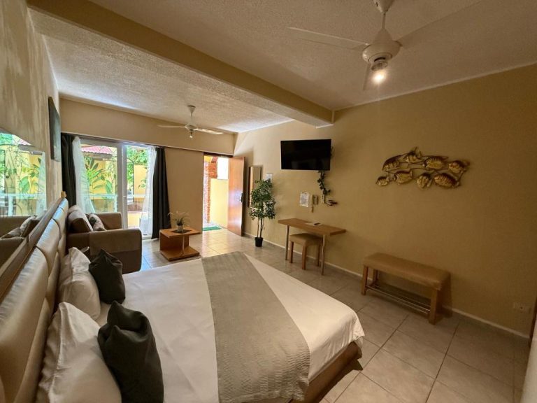 Habitación doble con cama king, sofá y televisor del Sosua Inn Hotel en República Dominicana
