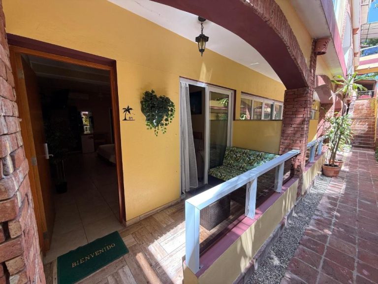 Terraza exterior con silla y entrada a habitación número 01 del Sosua Inn Hotel en República Dominicana
