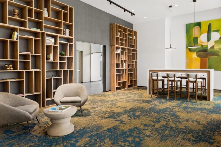Sala de estar con biblioteca de madera y zona de coworking en Homewood Suites by Hilton Cariari San José