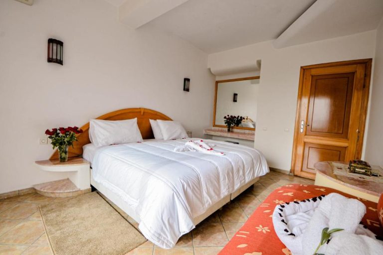 Habitación doble romántica con cama king size y rosas rojas en Intouriste Hotel & Suites