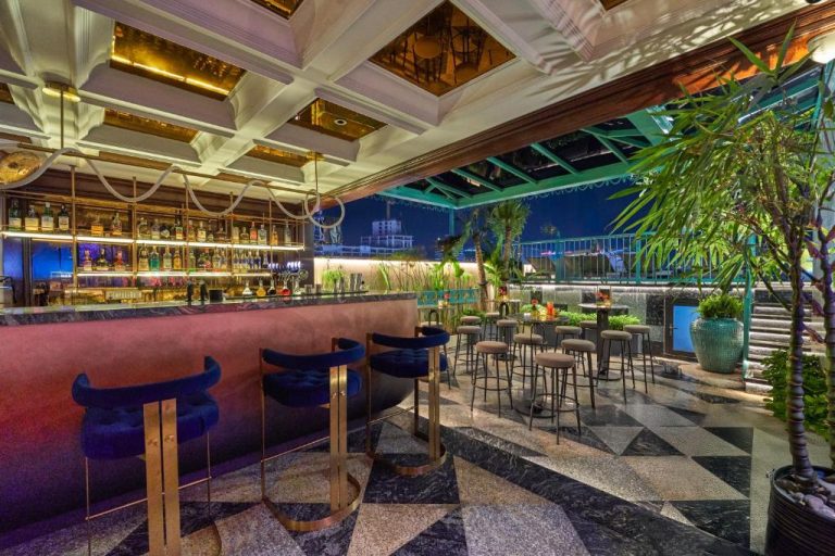 Bar en la azotea con ambiente nocturno y vistas panorámicas del Grand Hotel du Lac Boutique Saigon