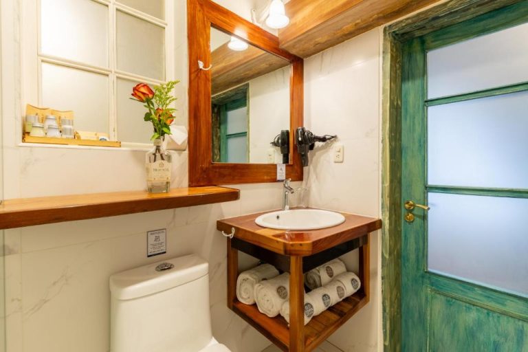 Baño rústico con lavabo de madera y detalles coloniales en Old Town Quito Suites Heritage Hotel