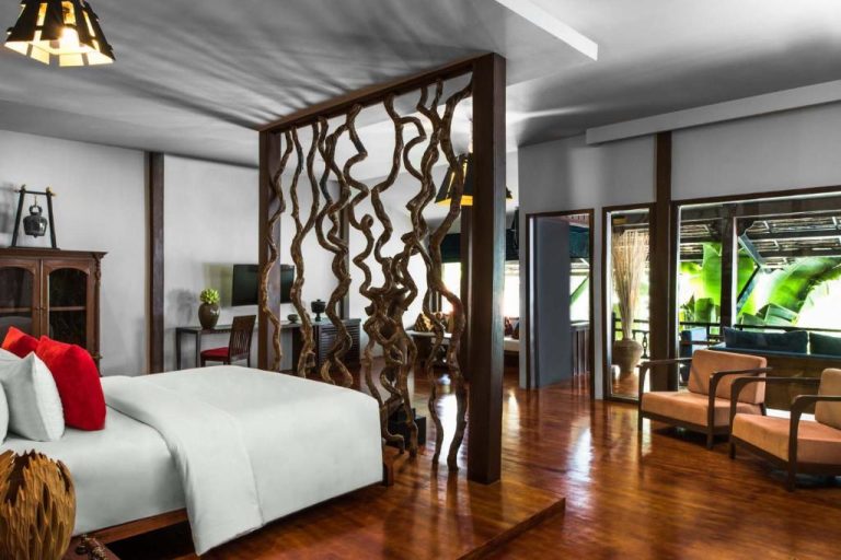 Habitación suite con decoración de raíces naturales y suelo de madera en Sokkhak Boutique Resort & Spa