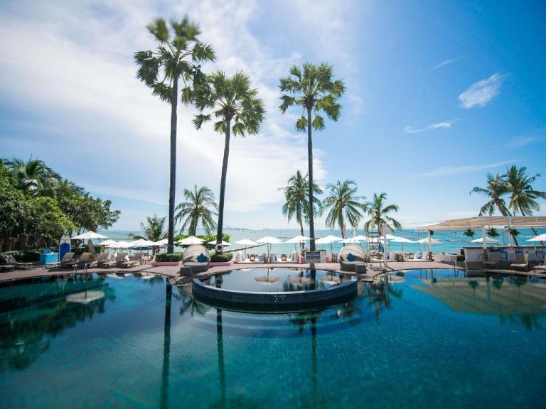 Piscina infinita con palmeras tropicales y vistas al mar del Pullman Pattaya Hotel G en Tailandia