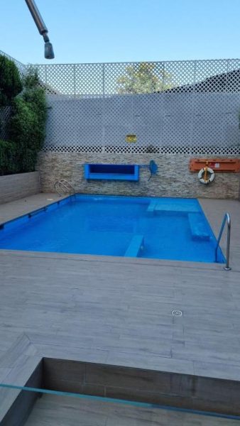 Piscina exterior azul del apartamento Lindo y cómodo en Santiago centro con zona de descanso