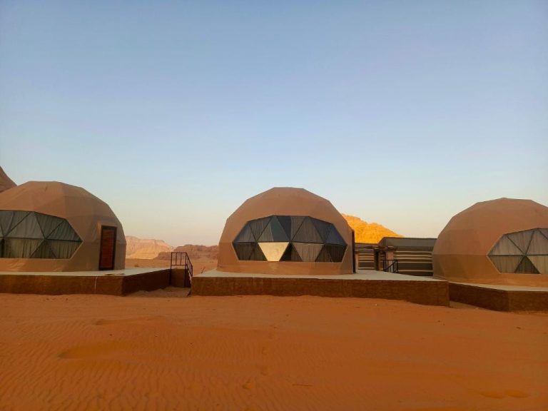 Domos geodésicos del Wadi Rum Marcanã Camp rodeados de arena roja y montañas del desierto de Jordania