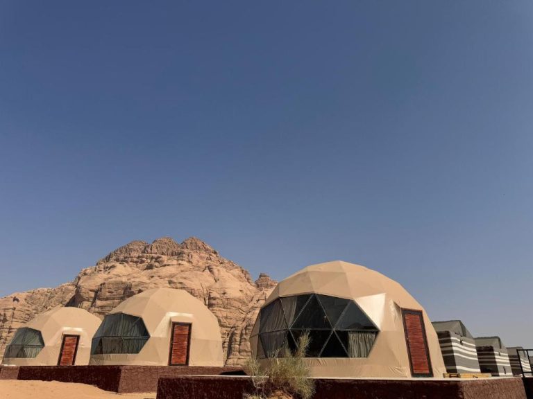 Domos geodésicos del Wadi Rum Marcanã Camp con formaciones rocosas del desierto al fondo