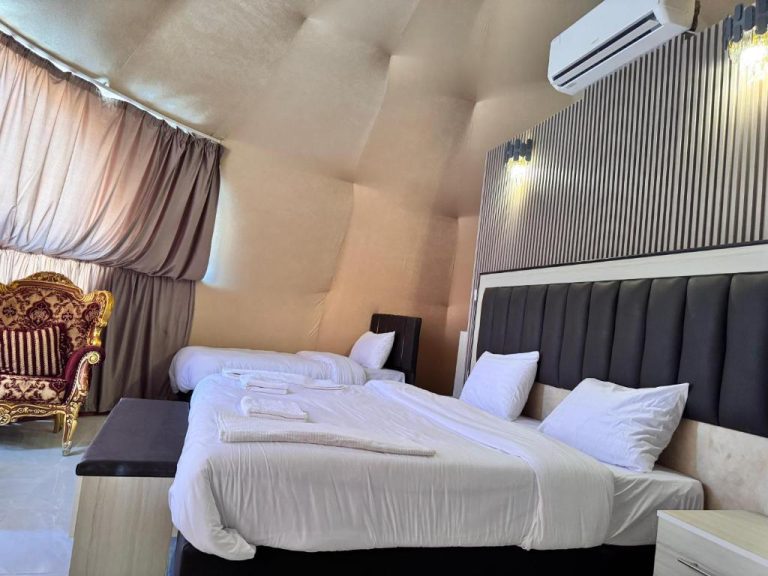 Habitación doble de lujo con dos camas y sillón clásico dorado en Wadi Rum Marcanã Camp