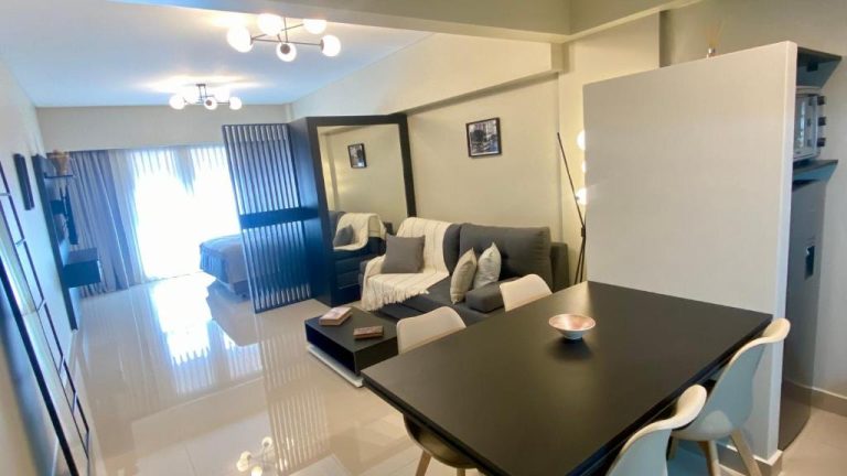 Salón comedor moderno con mesa negra y sofá gris en apartamento Centro Histórico Apart I