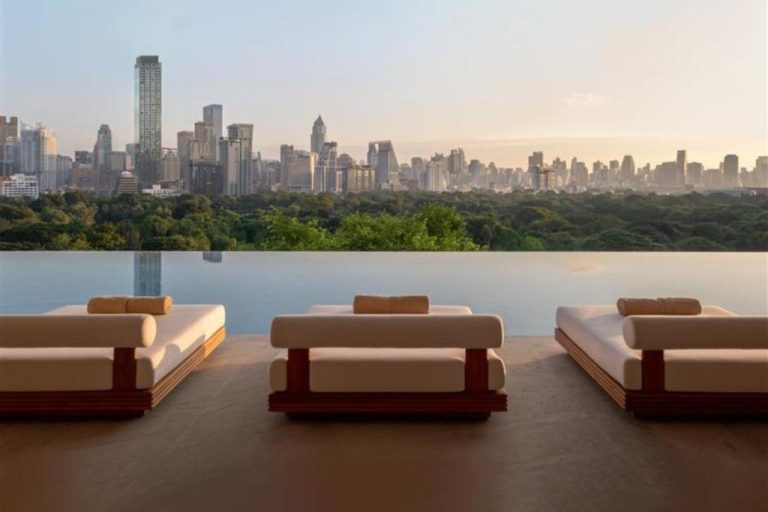 Piscina infinita con tumbonas de lujo y vistas al skyline de Bangkok en el Dusit Thani Bangkok