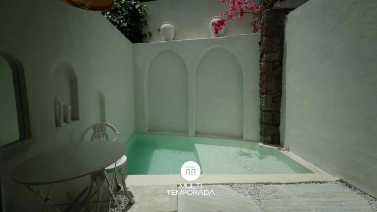 Pequeña piscina privada con paredes blancas y arcos decorativos en el patio del hotel CasaIvan