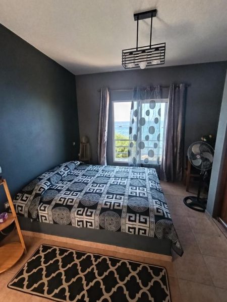 Habitación doble con decoración oscura y vista al mar en B&B Casa Boho