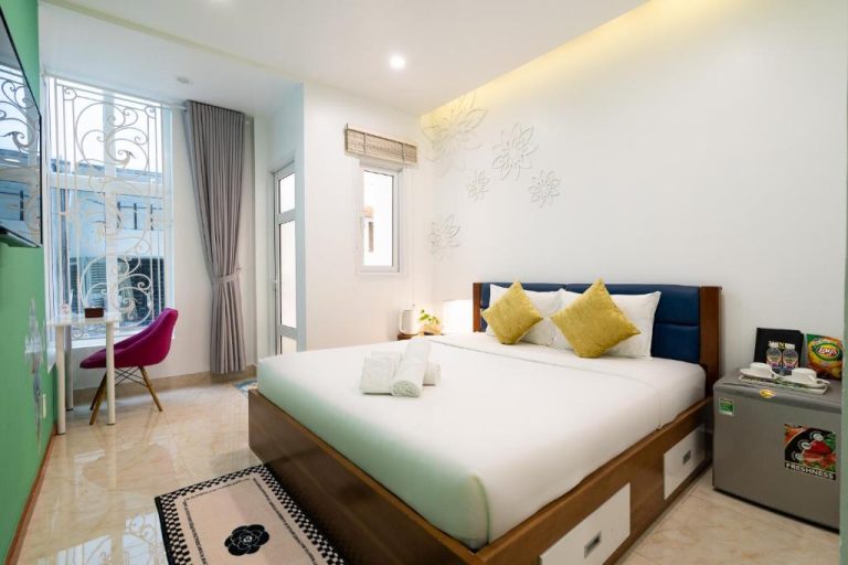 Habitación doble con cama matrimonial, almohadas amarillas y minibar en Adventure Hotel