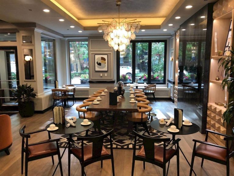 Elegante salón comedor del Claridge House Chicago con mesas vestidas y lámpara de araña de diseño