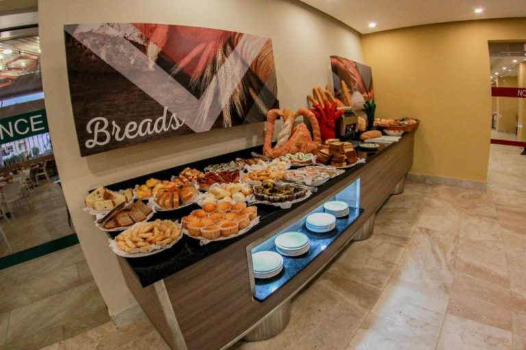 Estación de panadería con variedad de panes y bollería en el buffet del Emotions by Hodelpa Puerto Plata