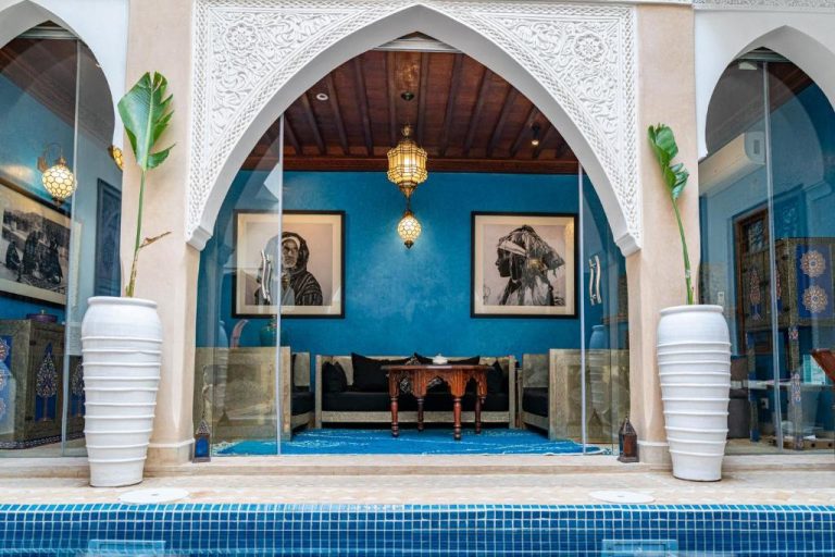 Patio interior con arcos árabes, piscina y salón decorado al estilo marroquí en Riad Serendip