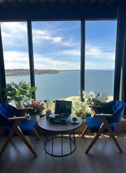 Salón con sillones azules y tocadiscos con vistas panorámicas al mar en Marina Boutique Hotel Istanbul Airport