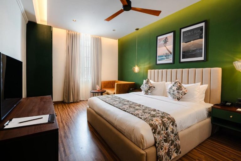 Habitación doble con pared verde y cama king size en el hotel MK Colombo, Sri Lanka