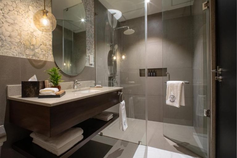 Baño moderno con ducha de cristal y lavabo empotrado en el hotel MK Colombo