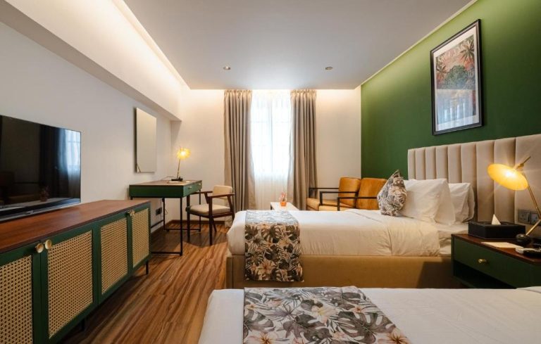 Habitación doble con decoración tropical y pared verde en el Hotel MK Colombo, Sri Lanka
