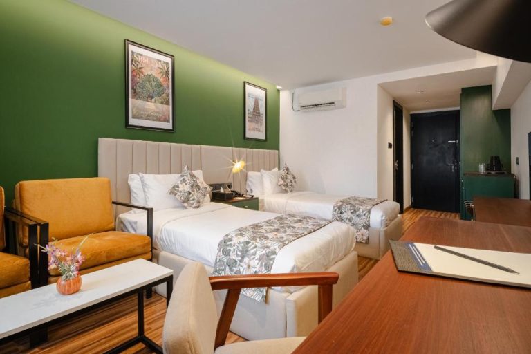 Habitación twin con dos camas y decoración en verde del hotel MK Colombo en Sri Lanka