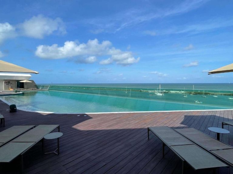 Piscina infinita con vistas al mar y marina del Novotel Recife Marina bajo cielo azul