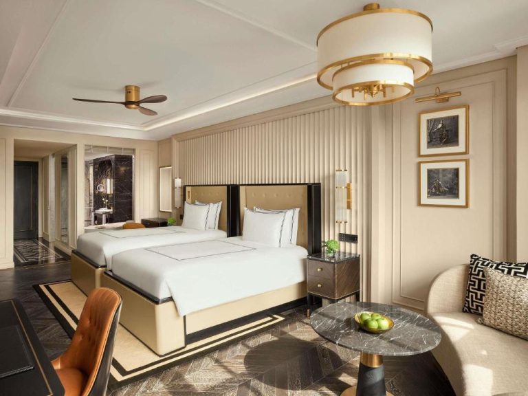 Habitación doble de lujo con dos camas y decoración elegante en dorado del Fairmont Mumbai