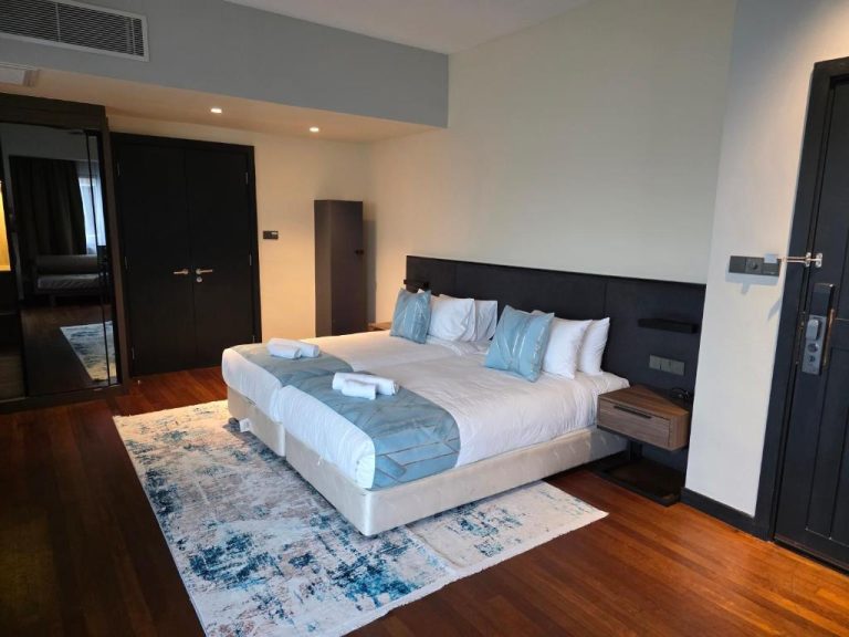 Habitación de lujo con cama doble king size y suelo de madera en Golden Palm Tree Suite Sepang