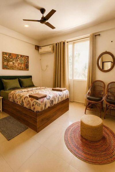 Habitación doble con decoración tropical y cama matrimonial en Hotel Amore Mio Morjim Beach