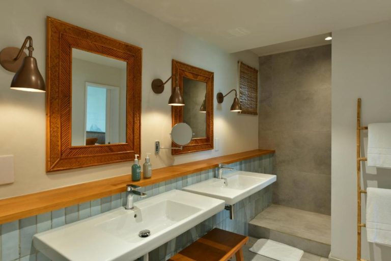 Baño doble con lavabos blancos y espejos de madera en Veranda Grand Baie Hotel & Spa