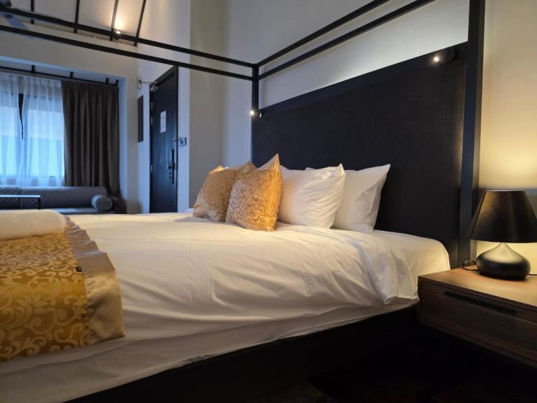 Habitación con cama doble y cabecero negro elegante en Golden Palm Tree Suite Sepang, Malasia