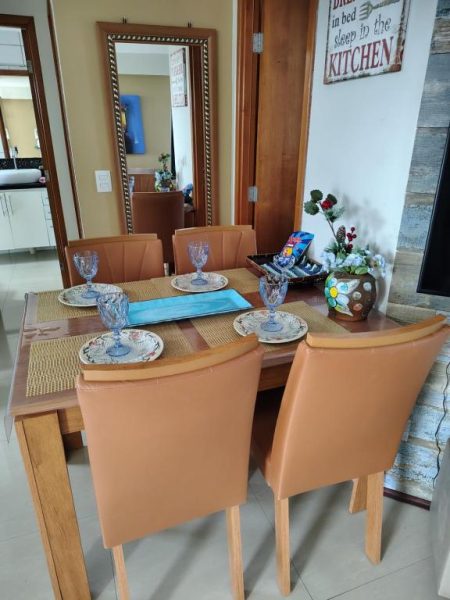 Comedor elegante con mesa de madera y sillas de cuero en Aptos Privativos Vista Mar Hotel Paradise Flat