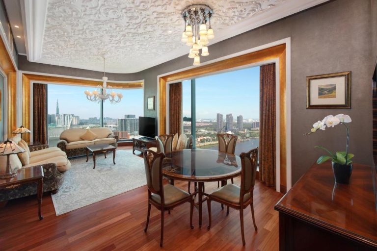 Suite de lujo con comedor y vistas panorámicas al río en The Reverie Saigon Residential Suites