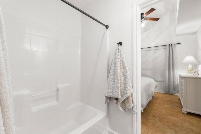Baño con bañera blanca y habitación principal en Shores of Panama Unit 108, Panama City Beach