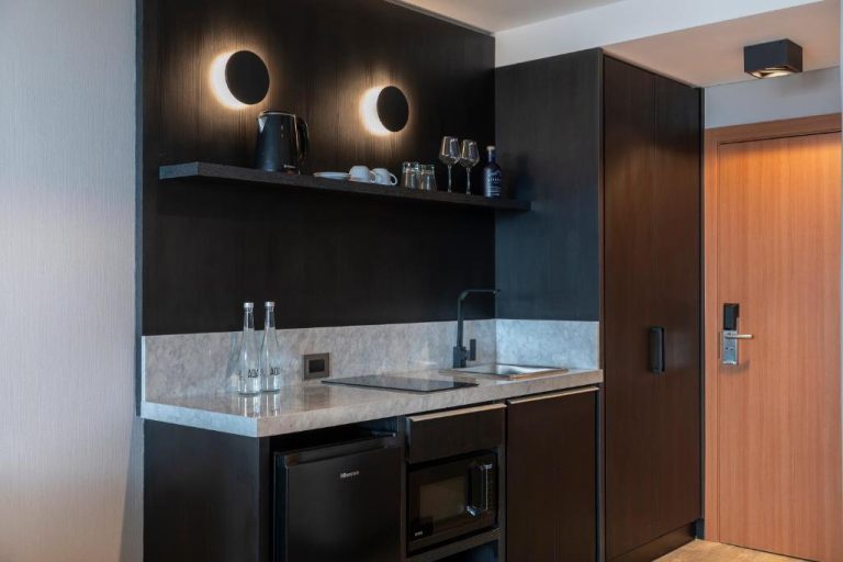 Kitchenette moderna con microondas, minibar y lavabo en habitación del Casa Joseph Libertador