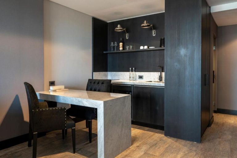 Cocina equipada con encimera de mármol y mesa de comedor en suite del Casa Joseph Libertador