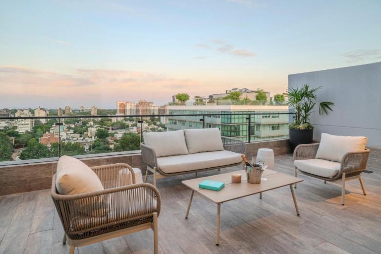 Terraza exterior con sofás y sillones de lujo y vistas panorámicas de la ciudad en Casa Joseph Libertador
