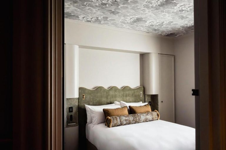 Habitación de lujo con cabecero verde ondulado y techo decorado con nubes en The Grand National Hotel by Saint Peter