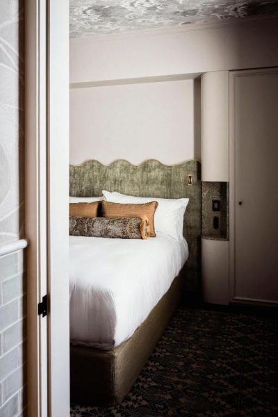 Habitación de lujo con cama doble y cabecero ondulado verde en The Grand National Hotel by Saint Peter