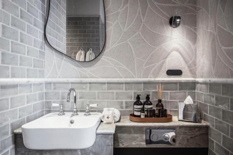 Baño de lujo con lavabo de mármol y productos Aesop en The Grand National Hotel by Saint Peter