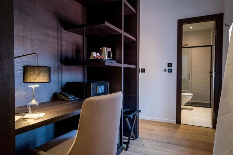 Escritorio de trabajo con lámpara y caja fuerte en habitación del Murum Heritage Hotel